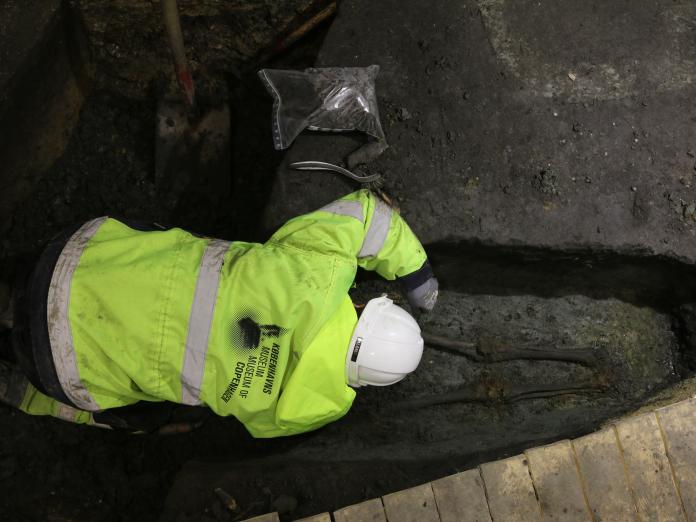 Arkæolog udgraver kiste med skelet