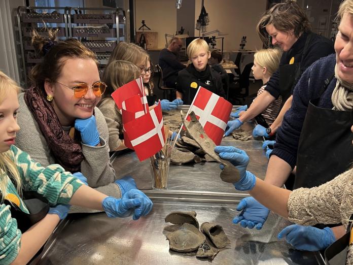 Børnefødselsdag i Arkæologisk Værksted med flag og blå plastikhandsker