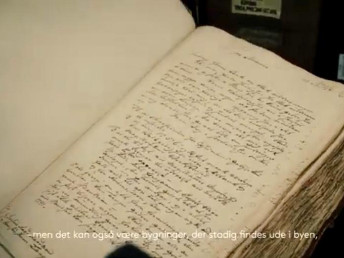 Stillfoto af bog med snirklet håndskrift