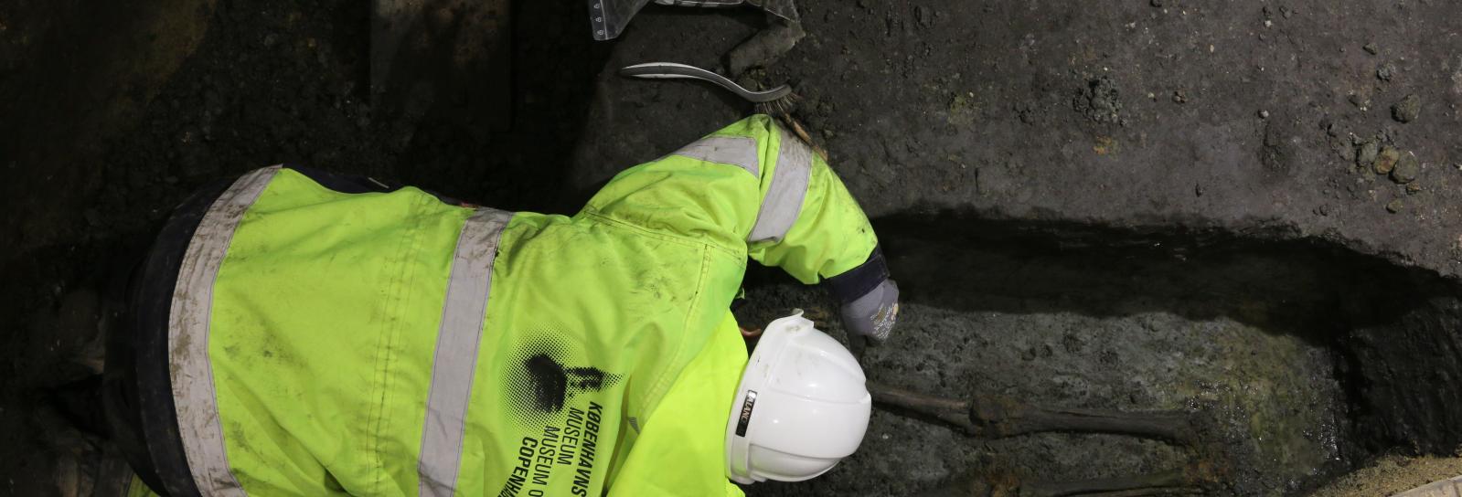 Arkæolog udgraver kiste med skelet