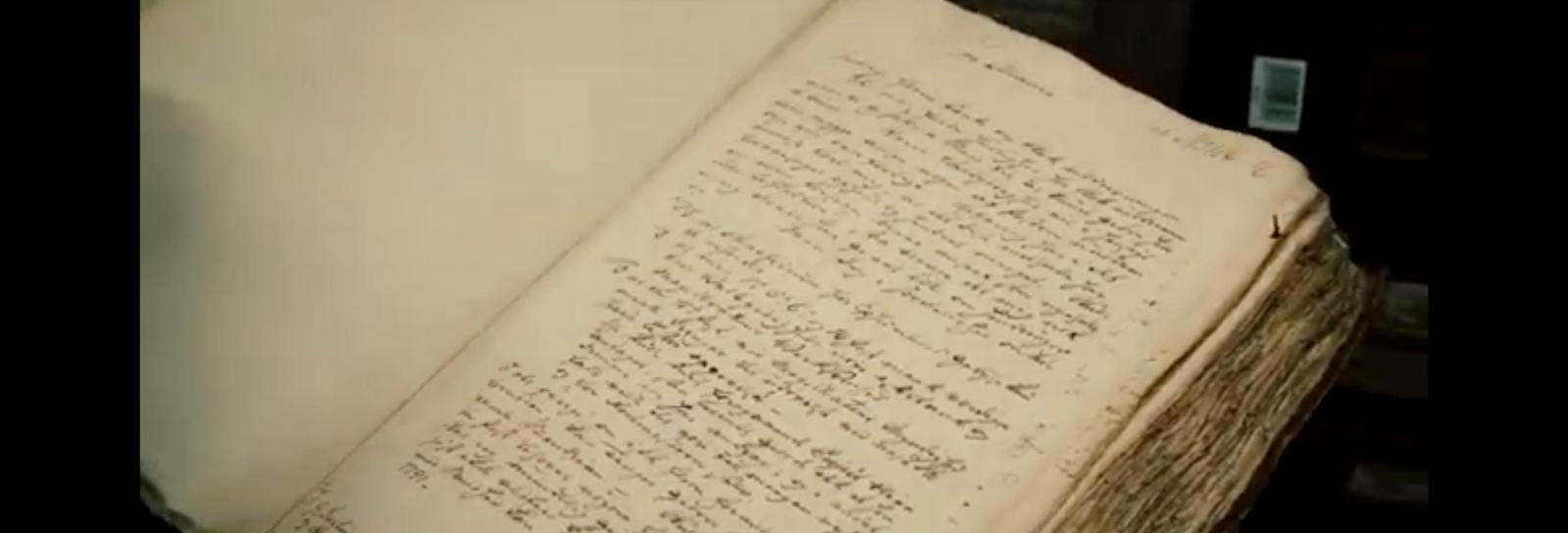 Stillfoto af bog med snirklet håndskrift